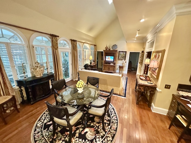 dining area with light hardwood / wood-style floors and high vaulted ceiling