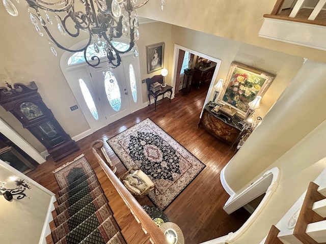 foyer with a high ceiling, dark hardwood / wood-style flooring, and a notable chandelier