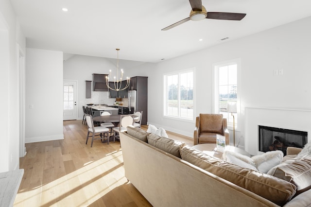 living area with light wood finished floors, a fireplace, visible vents, and a healthy amount of sunlight