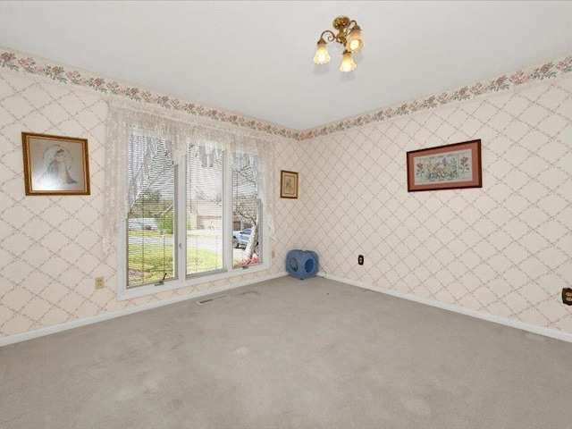 carpeted spare room featuring baseboards and wallpapered walls