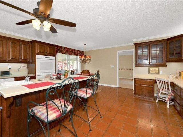 kitchen with a breakfast bar area, light countertops, a sink, and built in study area