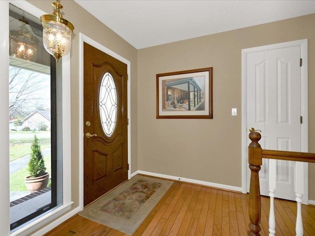 foyer with baseboards and wood-type flooring