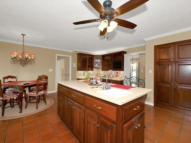 kitchen featuring light countertops, a sink, a textured ceiling, a center island, and ceiling fan with notable chandelier