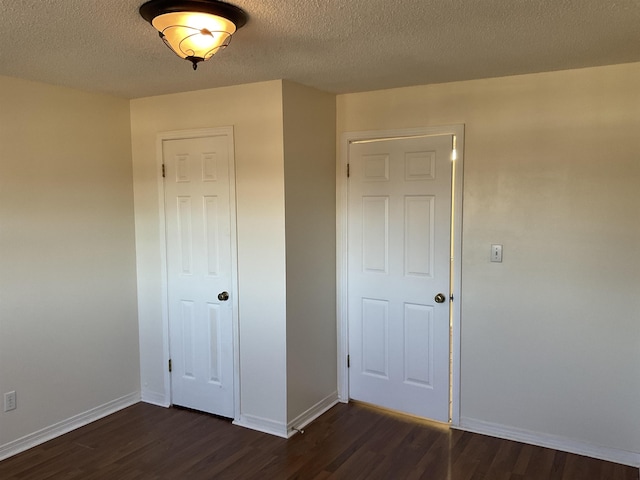 unfurnished bedroom with a closet, dark hardwood / wood-style floors, and a textured ceiling