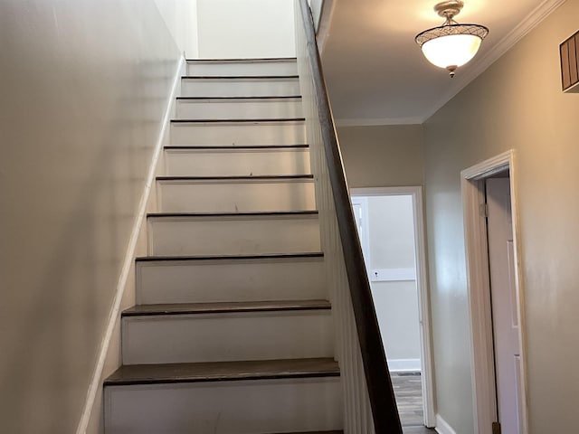 staircase with hardwood / wood-style flooring and ornamental molding