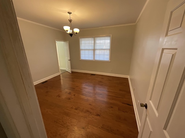 empty room with dark wood-type flooring, crown molding, and an inviting chandelier