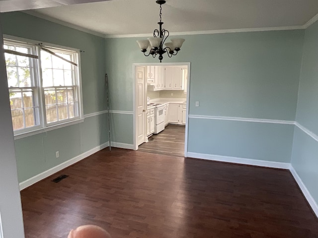 unfurnished dining area featuring dark hardwood / wood-style flooring, crown molding, and an inviting chandelier