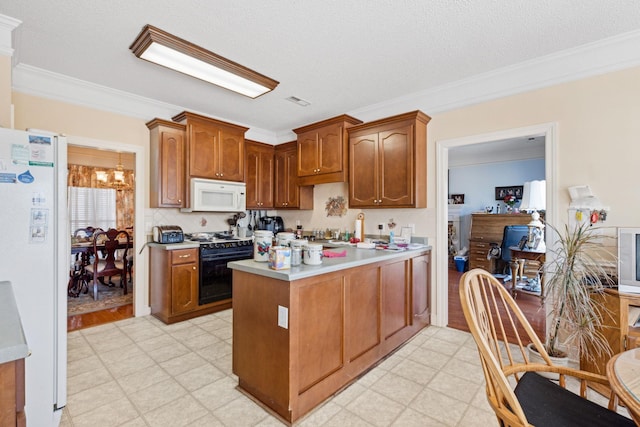 kitchen with white appliances, ornamental molding, a textured ceiling, and a notable chandelier