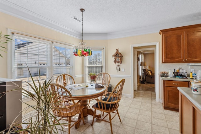 dining room featuring ornamental molding, a chandelier, and a textured ceiling