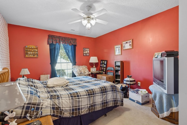 carpeted bedroom with ceiling fan and a textured ceiling