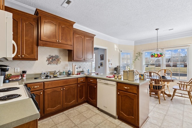 kitchen featuring pendant lighting, sink, white appliances, ornamental molding, and kitchen peninsula