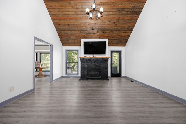 unfurnished living room with high vaulted ceiling, a brick fireplace, dark hardwood / wood-style flooring, wood ceiling, and a chandelier