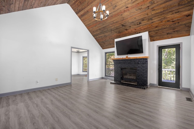 unfurnished living room with a brick fireplace, wood ceiling, hardwood / wood-style flooring, high vaulted ceiling, and a notable chandelier