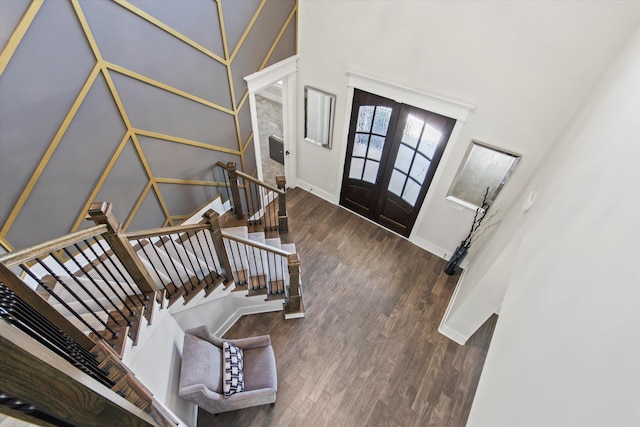 - entryway with baseboards, french doors, wood finished floors, and a towering ceiling