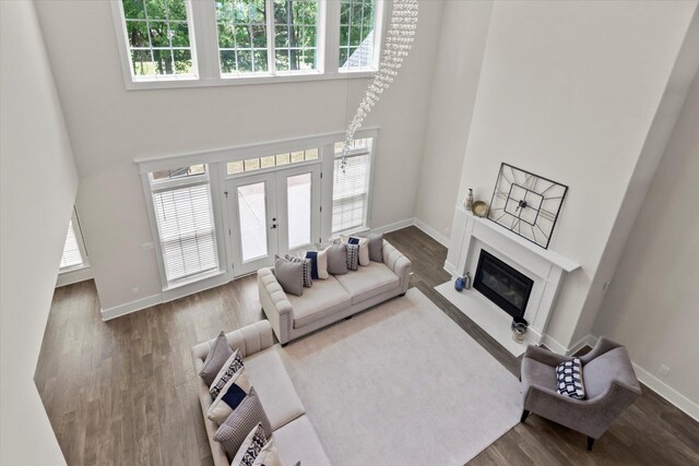  - living room featuring a healthy amount of sunlight, baseboards, and a high ceiling