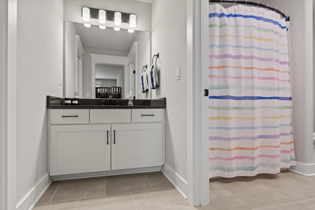  - full bath featuring baseboards, tile patterned flooring, vanity, and a shower with shower curtain