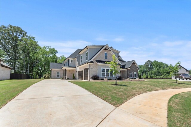  - craftsman house with concrete driveway, a front yard, and a garage
