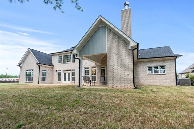  - rear view of house with brick siding, a chimney, french doors, a patio, and a yard