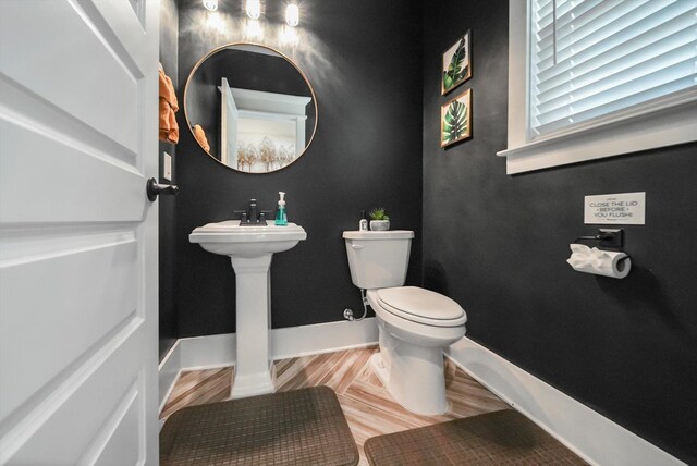  - bathroom featuring baseboards and toilet