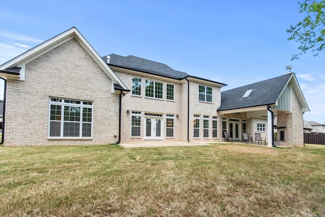  - back of house with french doors, a patio, a yard, and brick siding