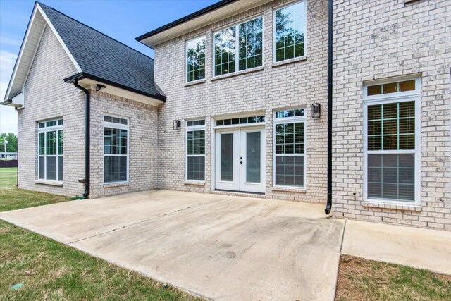  - back of house featuring roof with shingles, a patio, and brick siding