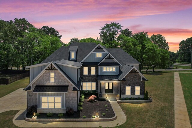 - craftsman-style house featuring a front yard, a standing seam roof, brick siding, board and batten siding, and metal roof