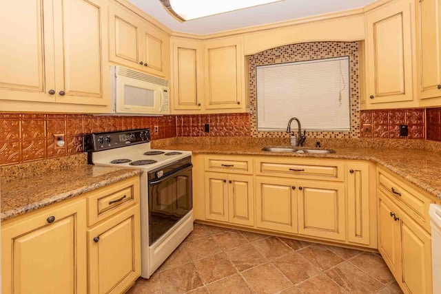 kitchen with backsplash, light stone countertops, white appliances, and sink