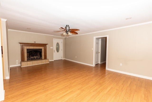 unfurnished living room featuring ceiling fan, a fireplace, light hardwood / wood-style floors, and ornamental molding