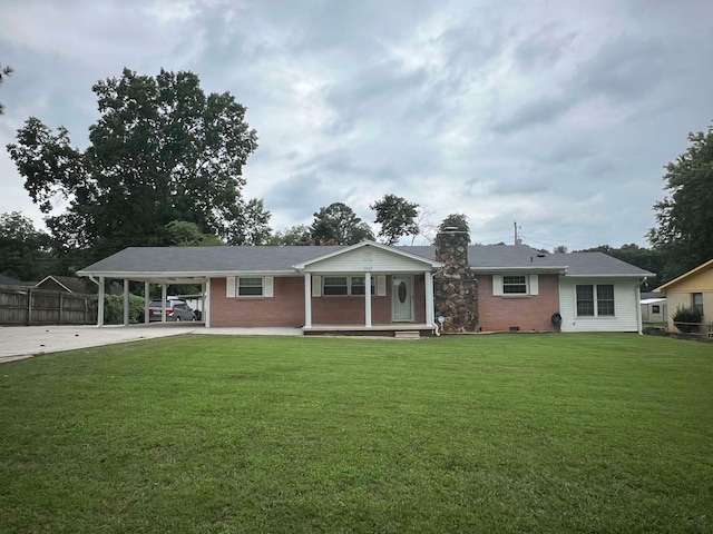 view of front of property with a carport, a front lawn, driveway, and a chimney