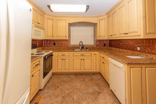 kitchen featuring backsplash, stone countertops, white appliances, and sink