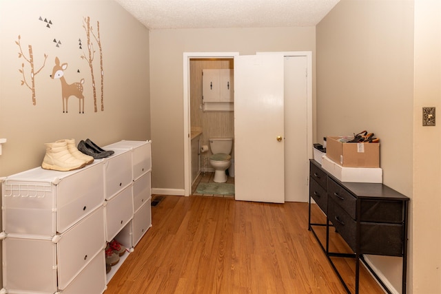 hall featuring a textured ceiling and light hardwood / wood-style flooring