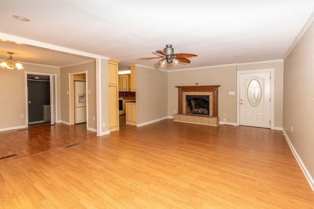 unfurnished living room featuring ceiling fan with notable chandelier, light hardwood / wood-style floors, ornamental molding, and a tiled fireplace