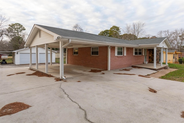 view of front of home featuring a carport, a garage, and an outbuilding