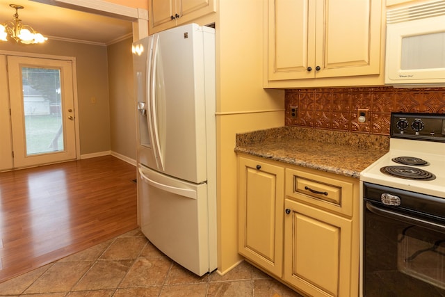 kitchen featuring tasteful backsplash, white appliances, crown molding, decorative light fixtures, and an inviting chandelier