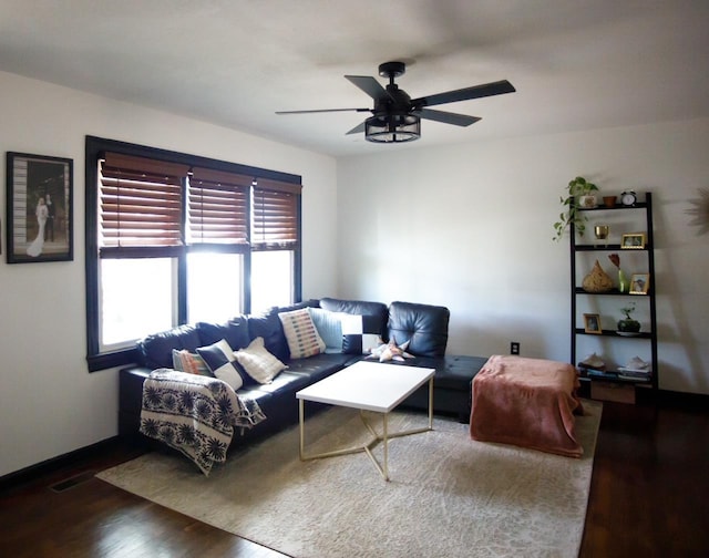 living room featuring ceiling fan and dark hardwood / wood-style floors