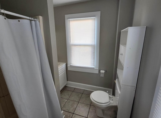 bathroom featuring tile patterned floors, a healthy amount of sunlight, and toilet