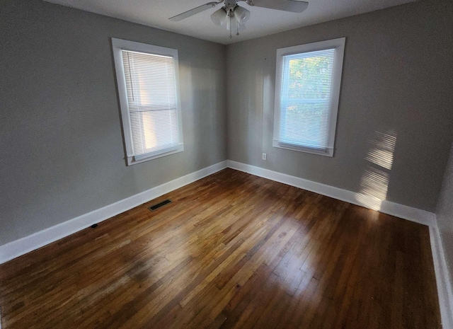 spare room featuring ceiling fan and dark wood-type flooring