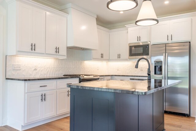 kitchen featuring custom exhaust hood, built in microwave, white cabinets, stainless steel fridge with ice dispenser, and a center island