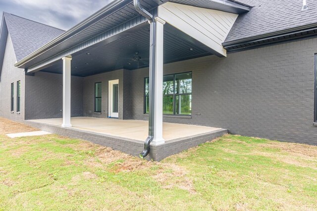 exterior space featuring ceiling fan, a patio area, and a lawn