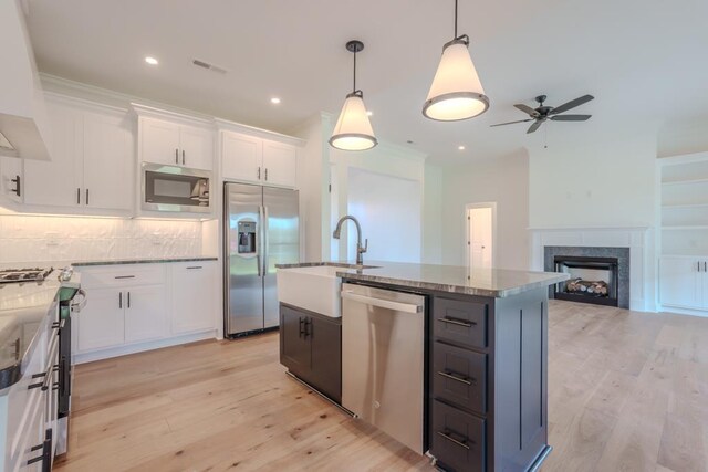 kitchen with white cabinets, a center island, pendant lighting, and appliances with stainless steel finishes