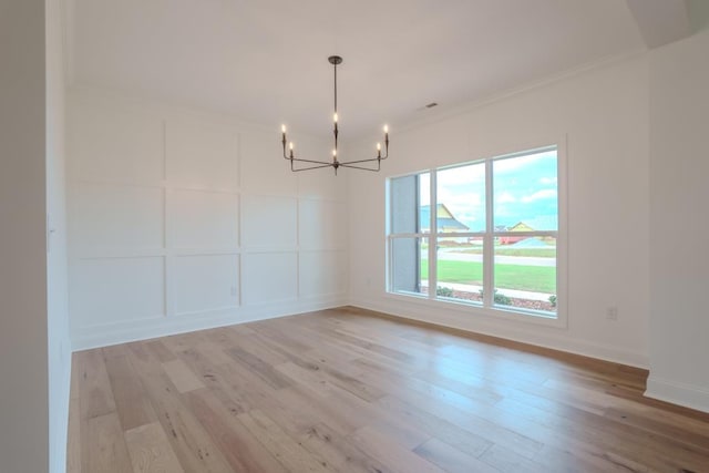 unfurnished dining area featuring a healthy amount of sunlight, light wood-type flooring, and ornamental molding