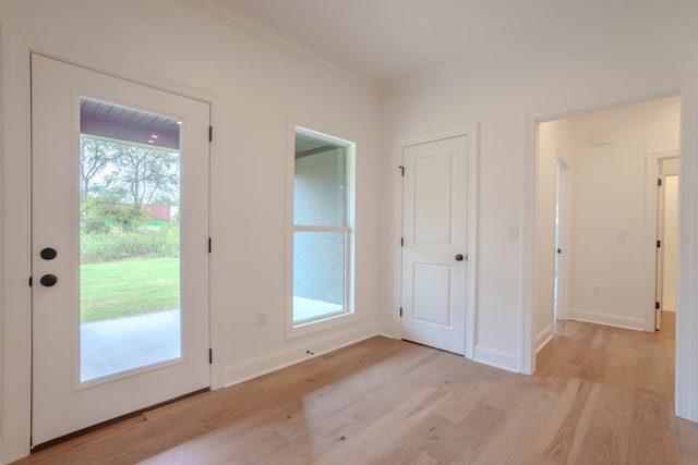 entryway with light hardwood / wood-style flooring and crown molding