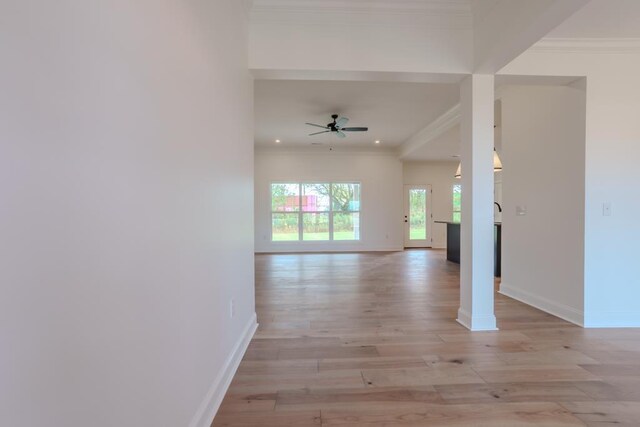 interior space featuring light wood-type flooring, ceiling fan, and ornamental molding