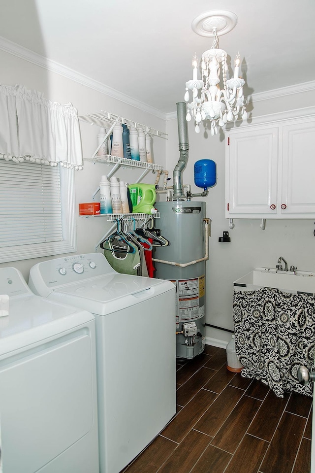  - clothes washing area featuring washing machine and dryer, gas water heater, ornamental molding, a chandelier, and dark wood-style floors
