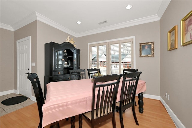  - dining room with hardwood / wood-style flooring and crown molding