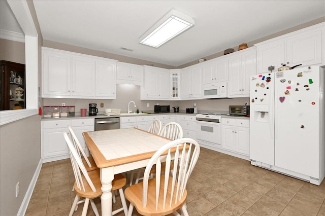  - kitchen with sink, white appliances, and white cabinets