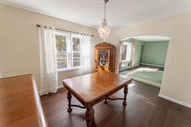 dining space featuring dark hardwood / wood-style floors and an inviting chandelier