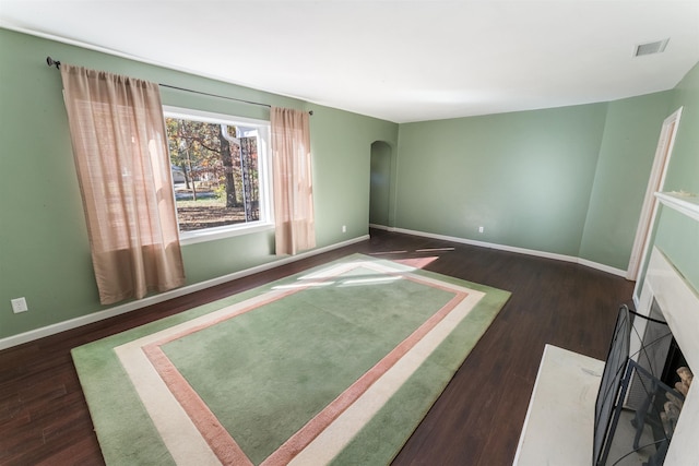 spare room featuring dark hardwood / wood-style flooring and a high end fireplace