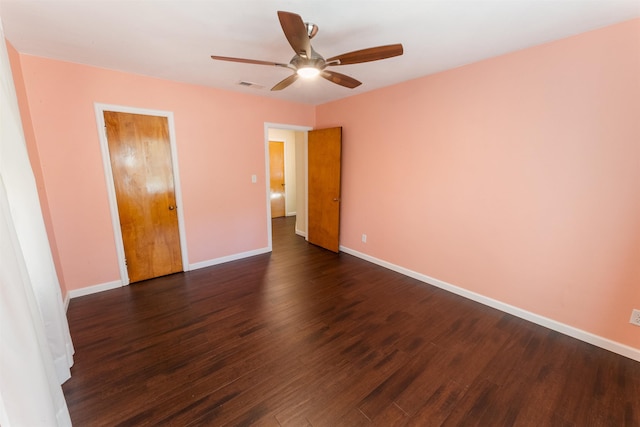 unfurnished room with ceiling fan and dark wood-type flooring