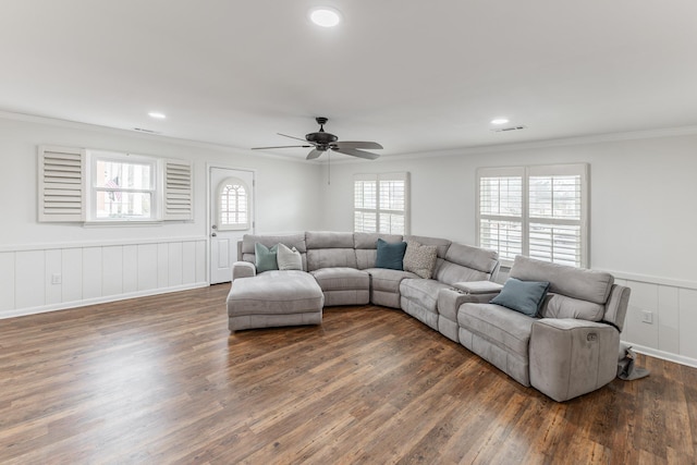 living area featuring dark wood-style floors, ornamental molding, and a wainscoted wall